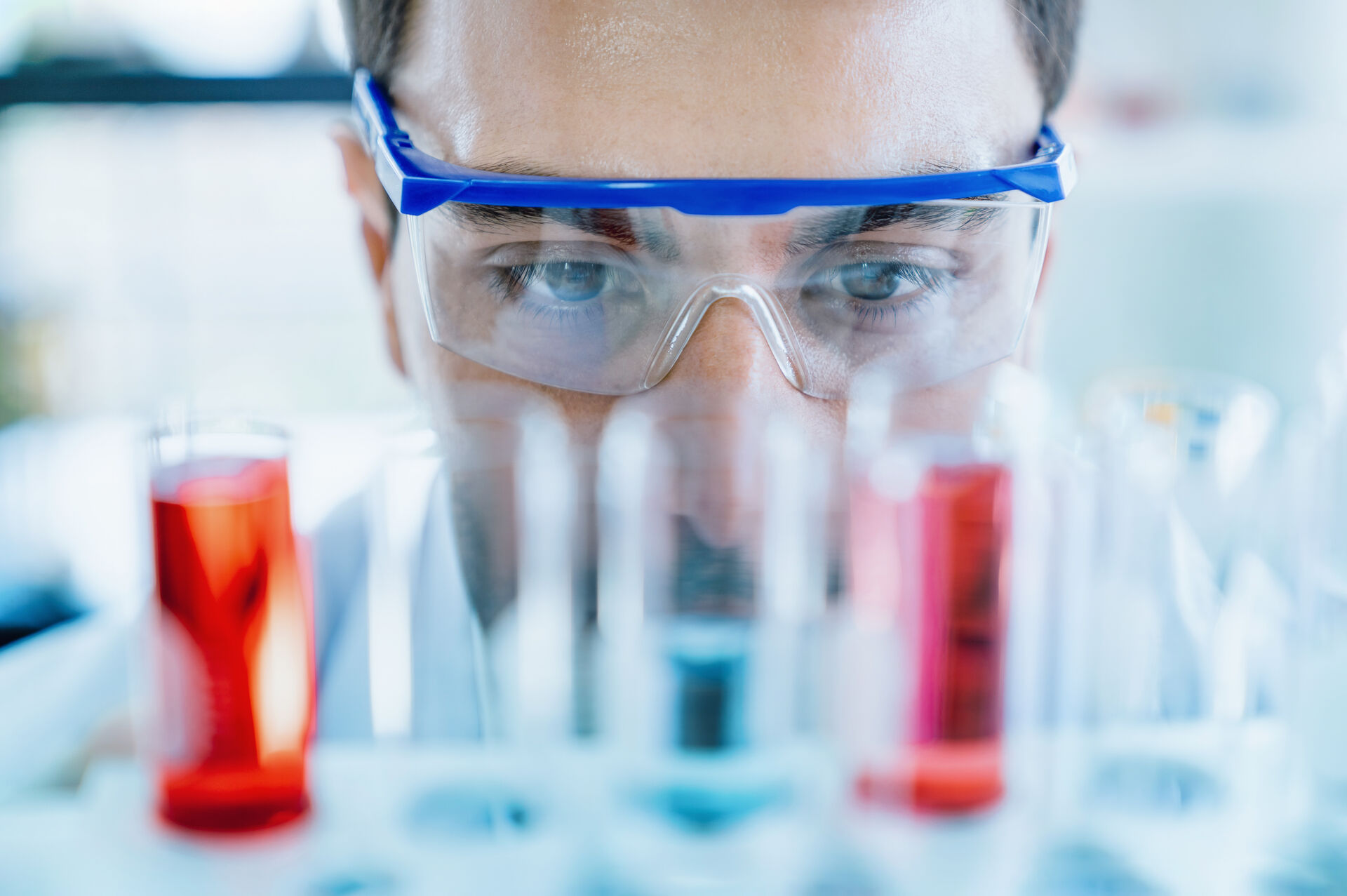 close_up_scientist_looking_at_test_in_glass_tube_while